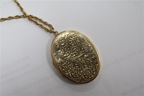 An engraved 9ct gold oval locket on a 9ct chain, locket 4cm.